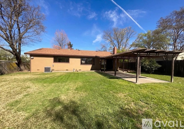 A house with a brown roof and a covered patio area.