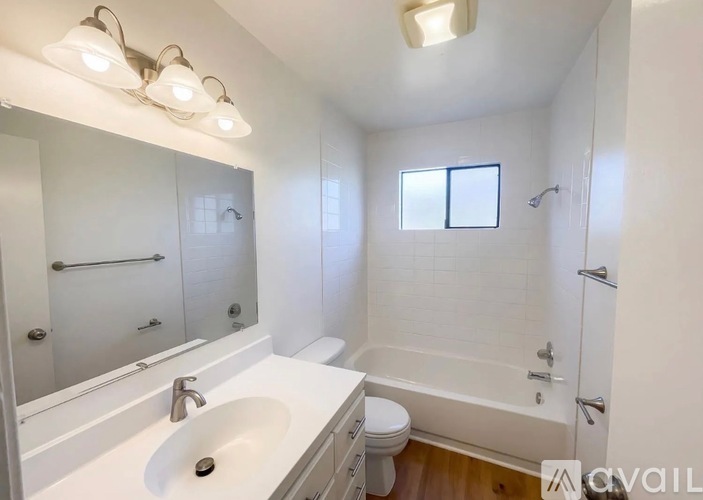 A bathroom with a white sink, toilet, and bathtub.