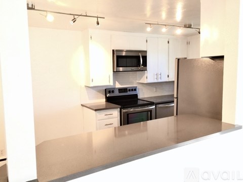 A kitchen with white cabinets and stainless steel appliances.