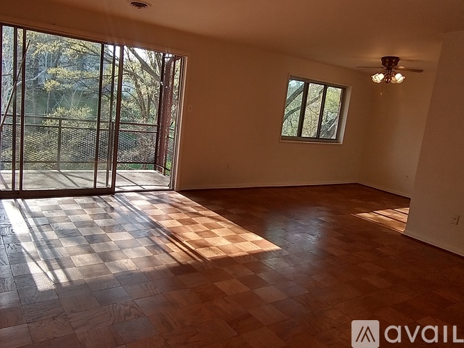 A room with a checkered floor and a window overlooking a fence.