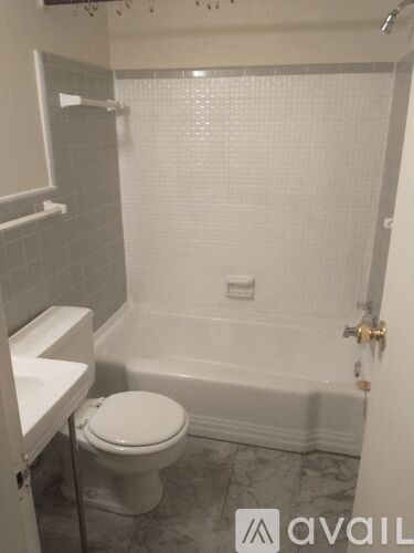 A white toilet is in a bathroom with a walk-in shower.