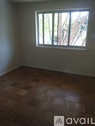 A room with a window and wooden flooring.