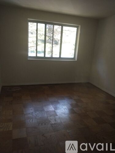 A room with a window and wooden flooring.