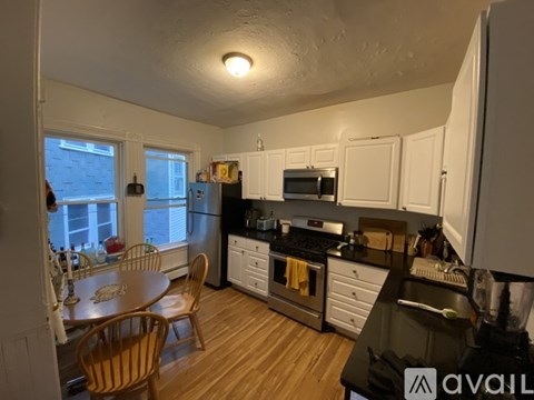 A kitchen with a table and chairs in front of a window.