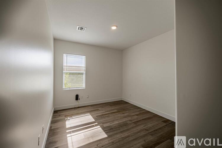A room with wooden flooring and a window letting in natural light.
