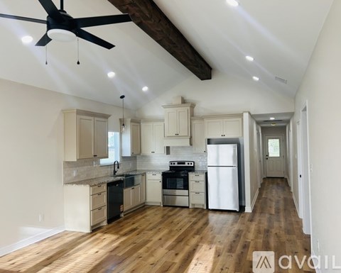 A kitchen with wooden floors and a ceiling fan.