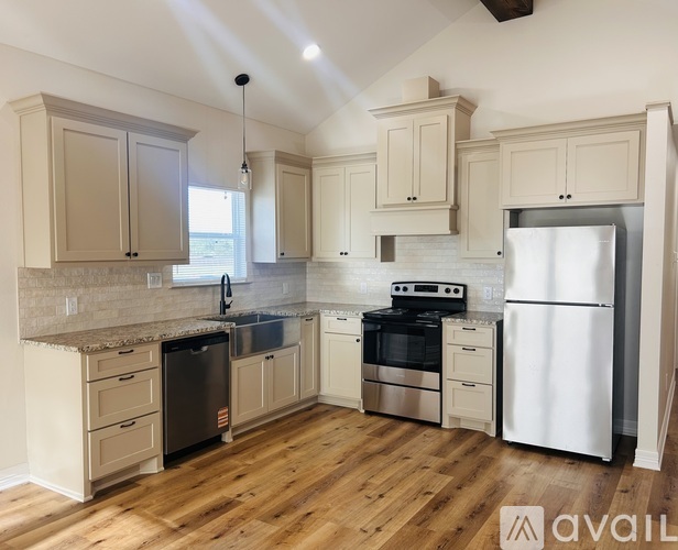 A kitchen with wooden floors and white appliances.
