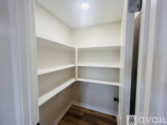 A white closet with shelves and a door.