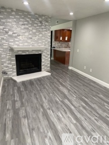 A living room with a fireplace and wooden flooring.