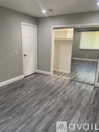 A room with grey flooring and a white door.