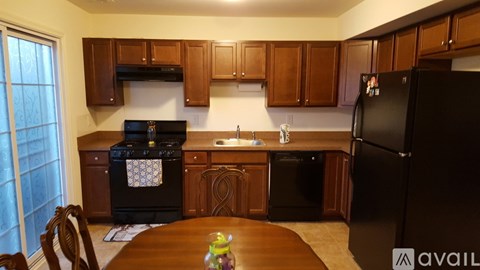 A kitchen with wooden cabinets and black appliances.