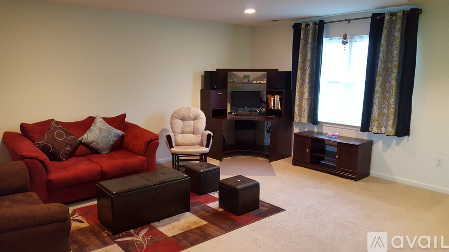 A living room with a red couch, a chair, and a coffee table.