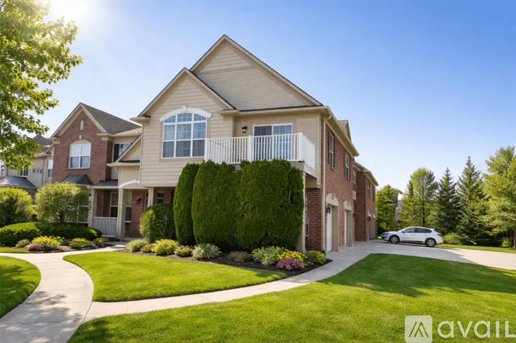 A large, well-maintained house with a car parked in front.