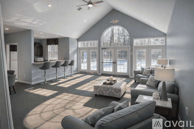 A living room with a grey couch and a large window.