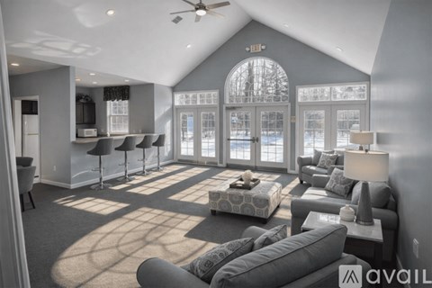 A living room with a grey couch and a large window.