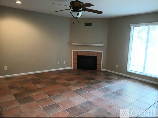A room with a fireplace and a ceiling fan.