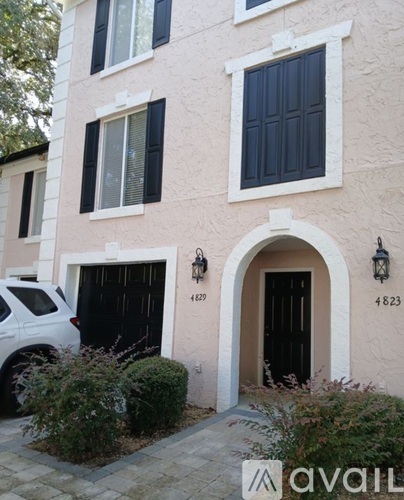 A two-story building with black shutters and a white garage door.