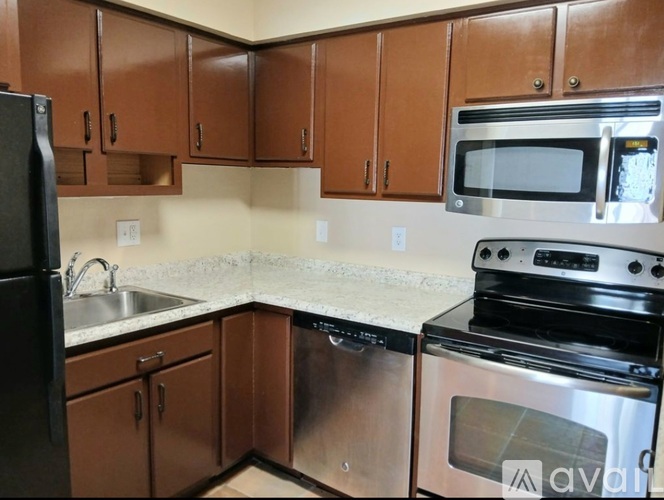 A kitchen with brown cabinets and stainless steel appliances.