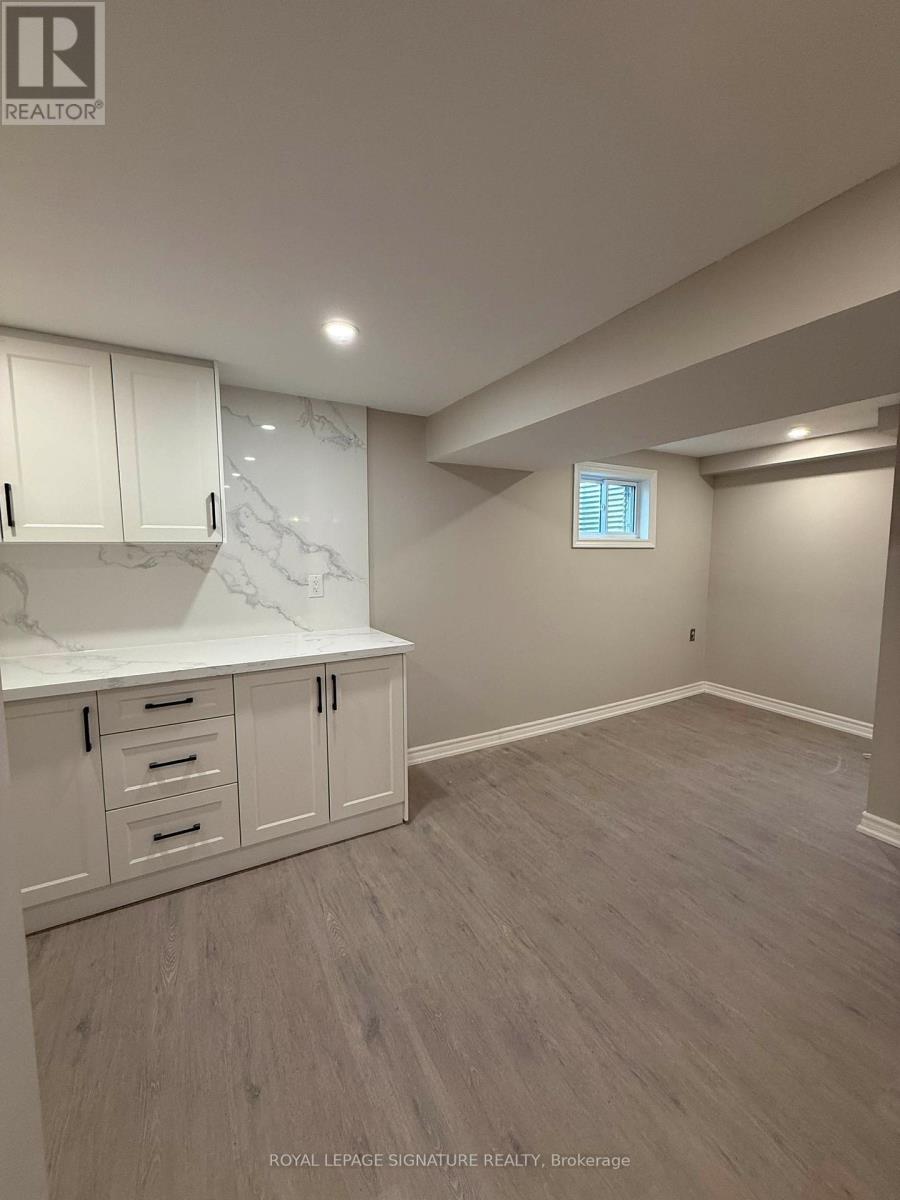 A room with white cabinets and a marble countertop.