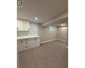 A room with white cabinets and a marble countertop.