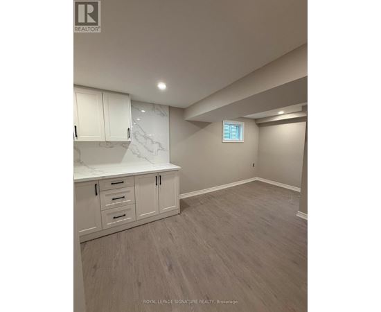 A room with white cabinets and a marble countertop.