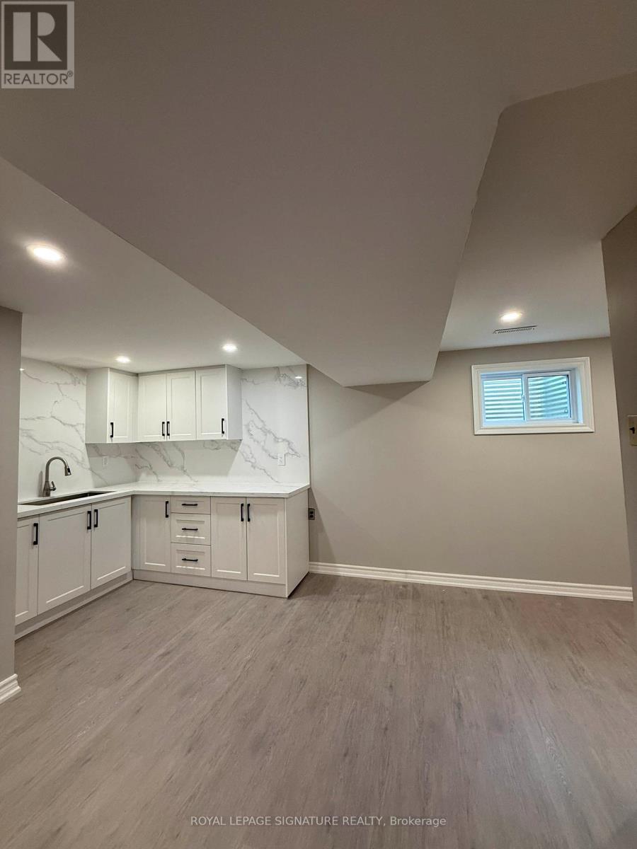 A kitchen with white cabinets and a window.