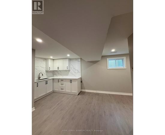 A kitchen with white cabinets and a window.