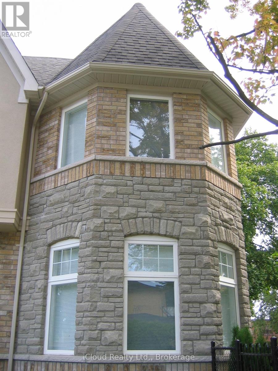 A stone house with a brown roof and a window with blinds.