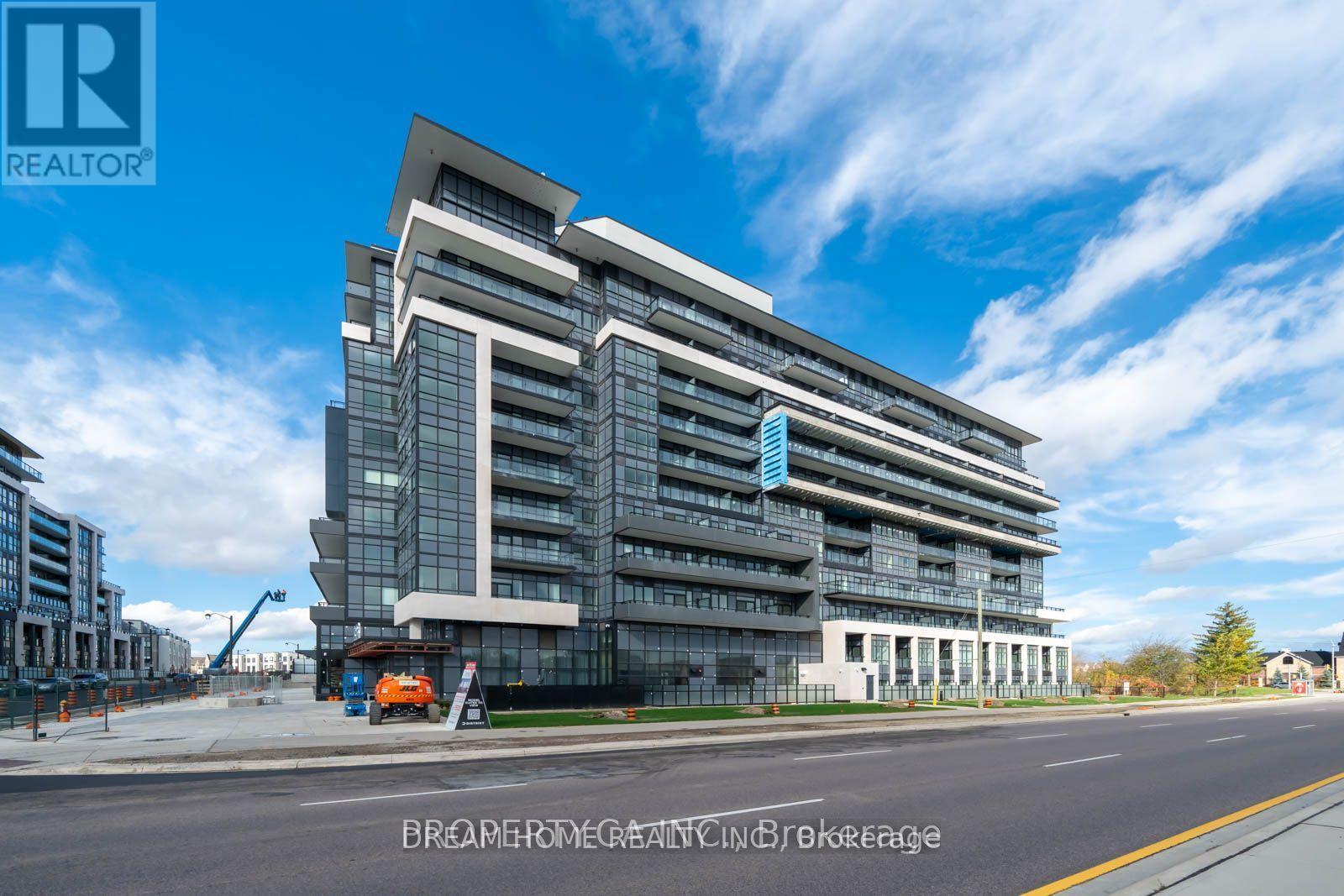 A modern multi-story building with a glass facade is under construction.