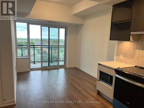 A kitchen with a stove top oven and a large window with a view.