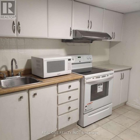A white kitchen with a Realty Inc. logo.