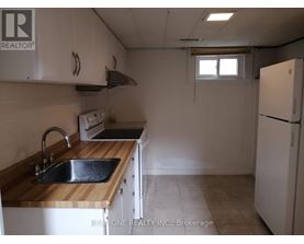 A kitchen with a sink, stove, and refrigerator.