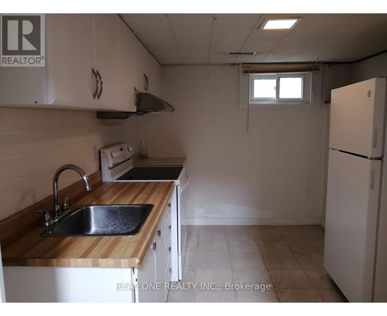 A kitchen with a sink, stove, and refrigerator.
