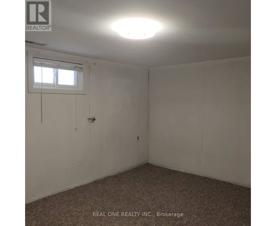 A room with a window and a carpeted floor.