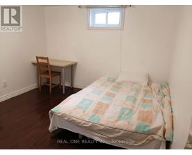 A bedroom with a bed, desk, and chair.