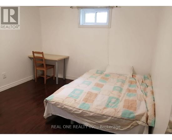 A bedroom with a bed, desk, and chair.