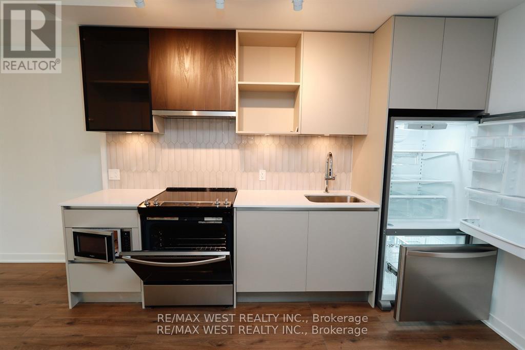 A modern kitchen with white cabinets and a wooden backsplash.