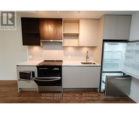 A modern kitchen with white cabinets and a wooden backsplash.