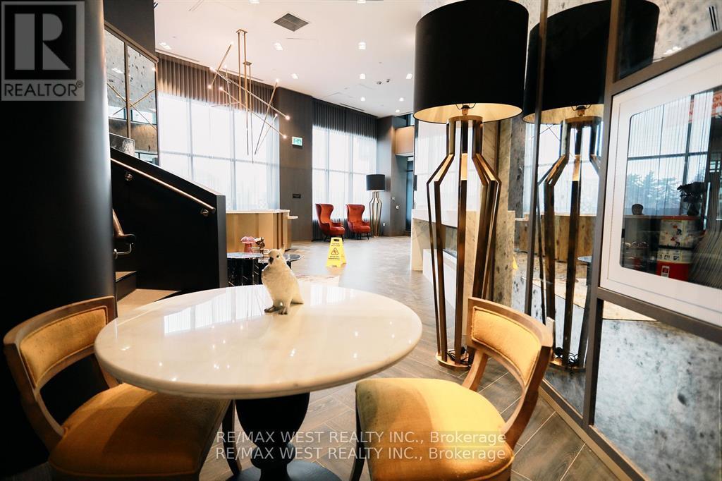 A white cat sits on a table in a modern dining room.