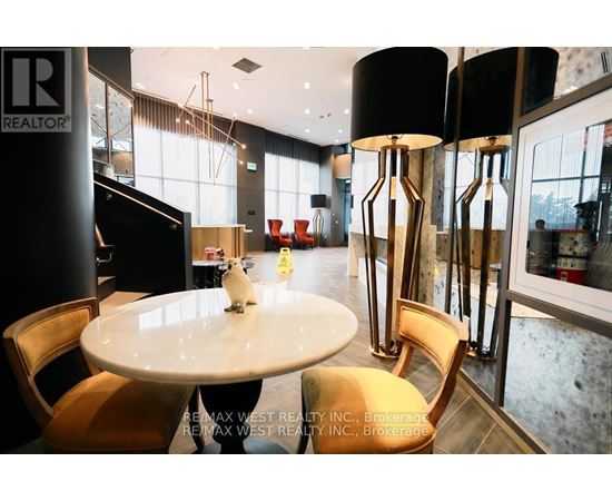 A white cat sits on a table in a modern dining room.