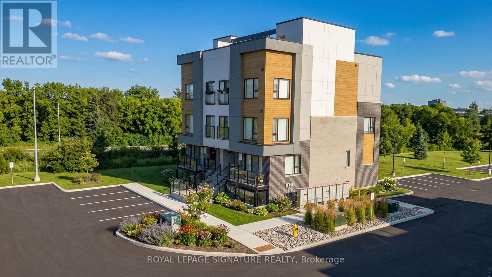 A modern multi-story building with a parking lot in front.