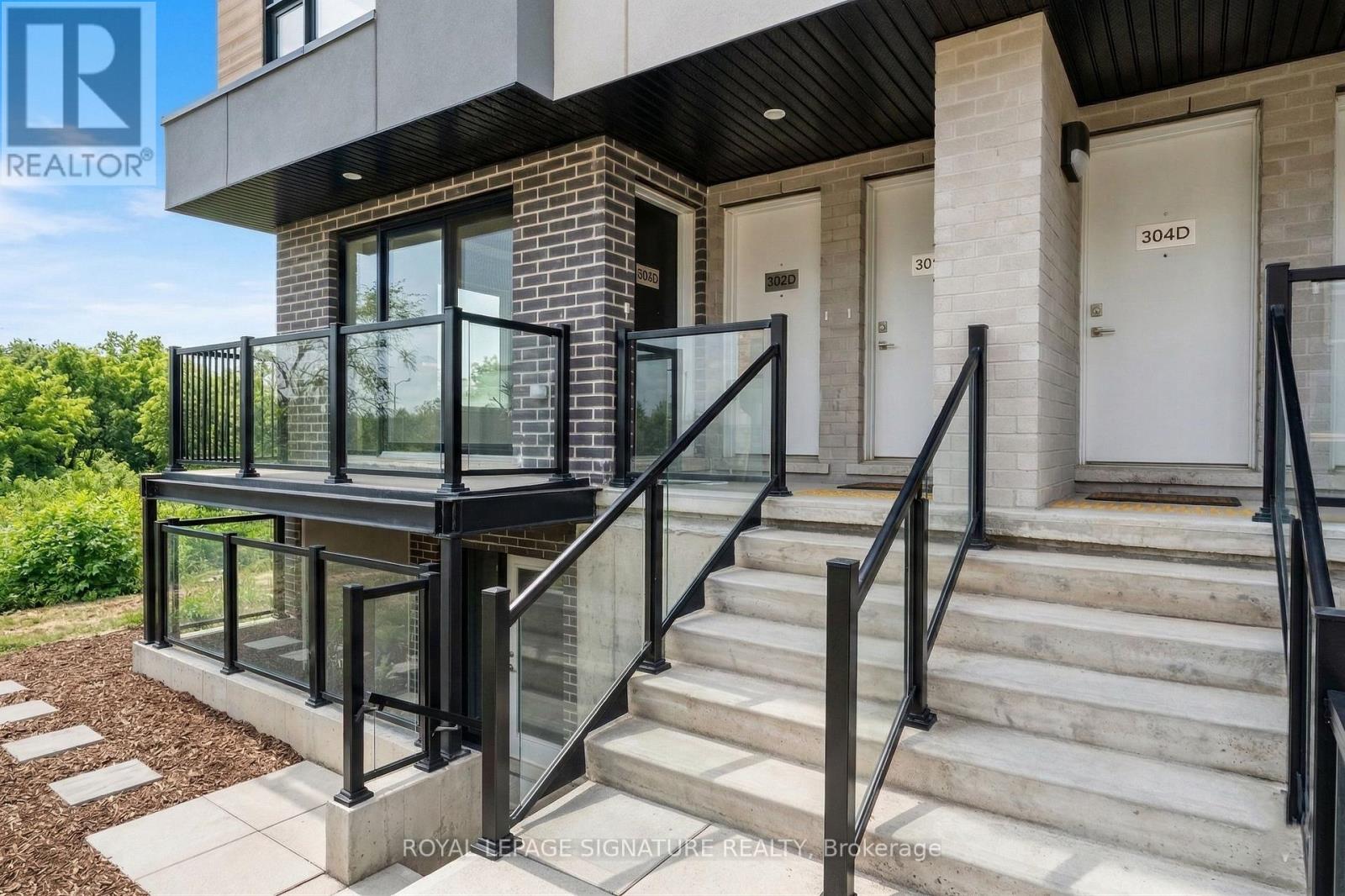 A modern house with a glass railing on the stairs.