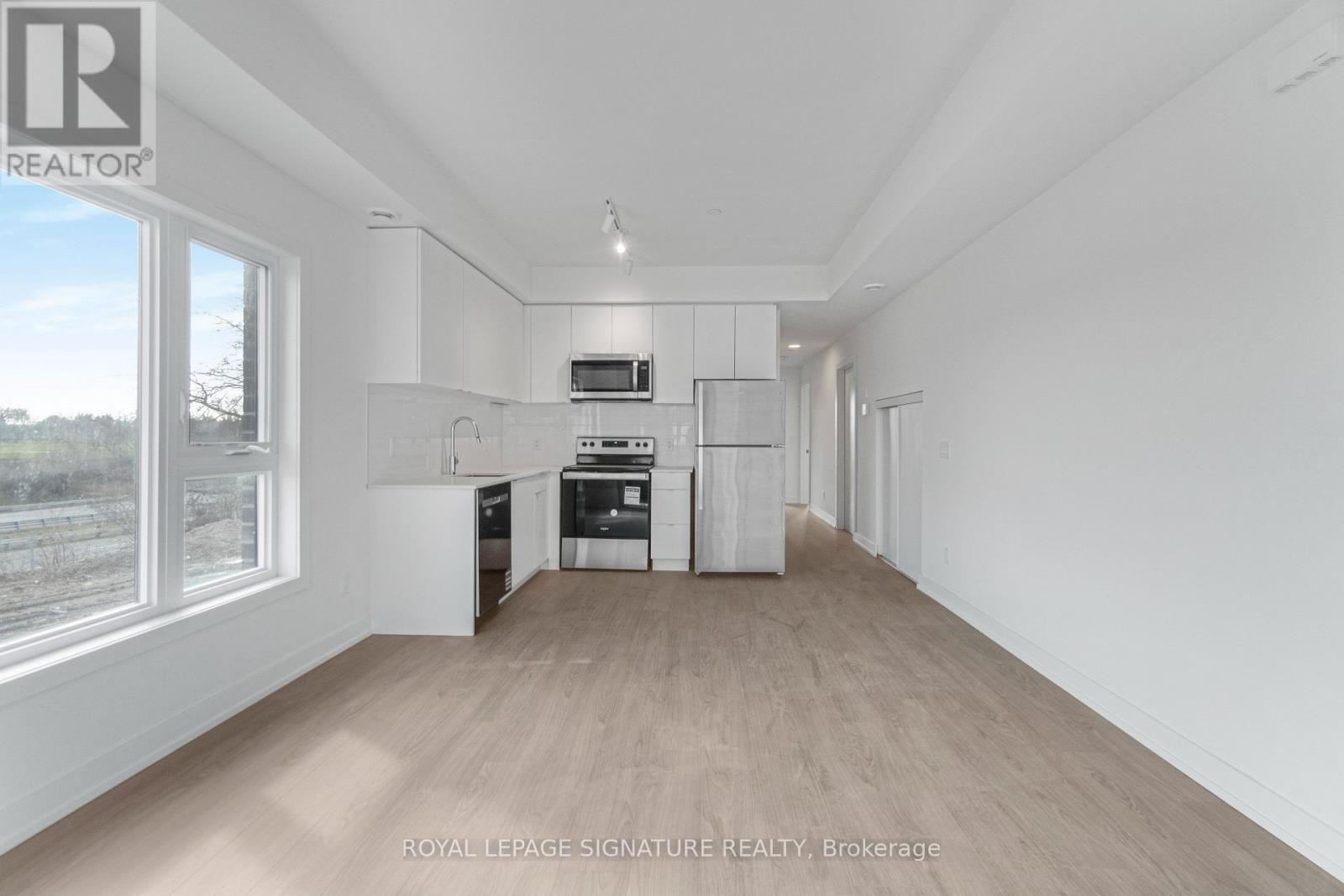 A spacious, empty room with white walls and wooden flooring.