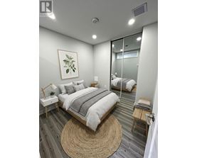 A bedroom with a bed, nightstand, and a rug.