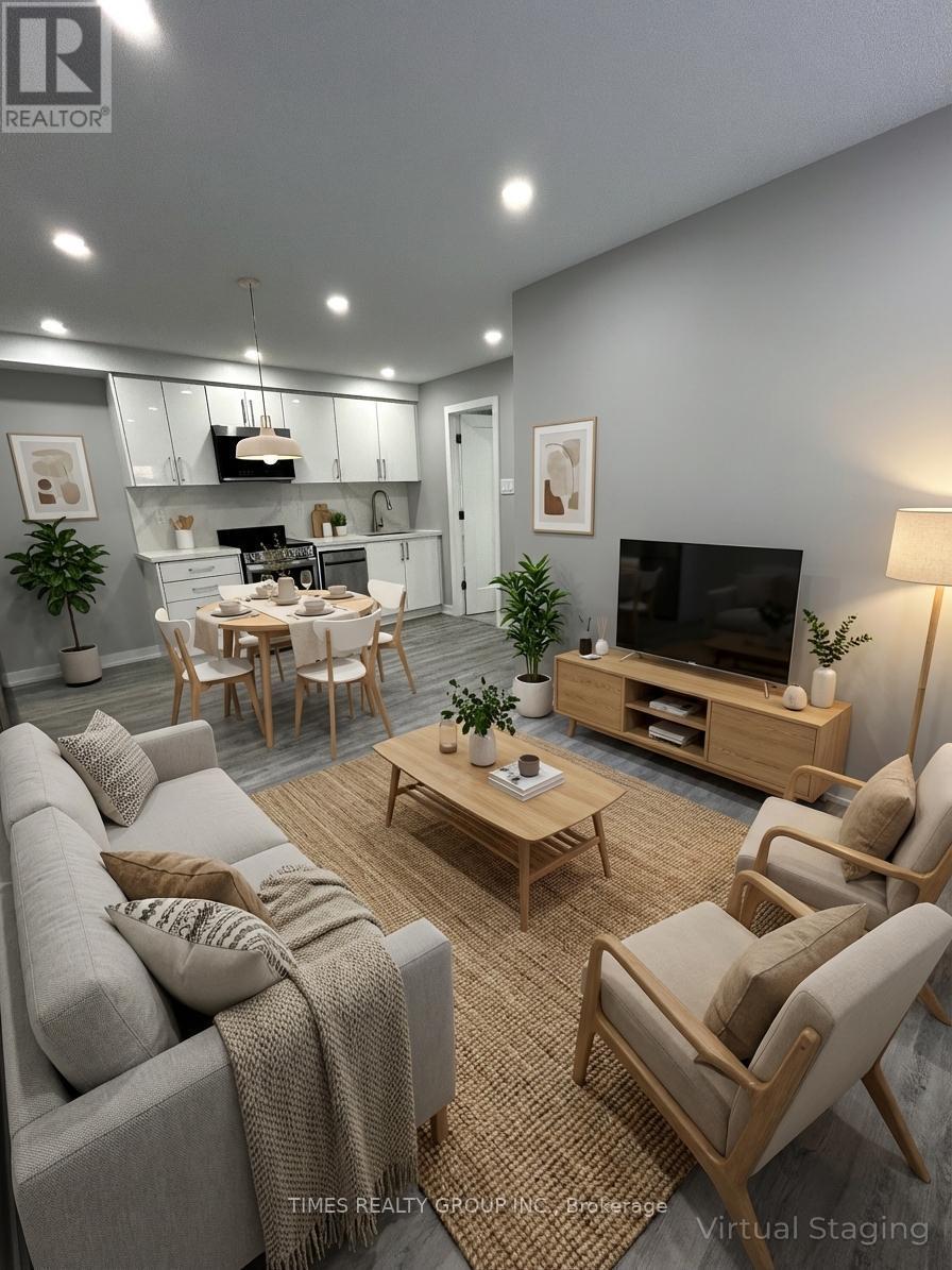 A modern living room with a grey couch, wooden chairs, and a television.