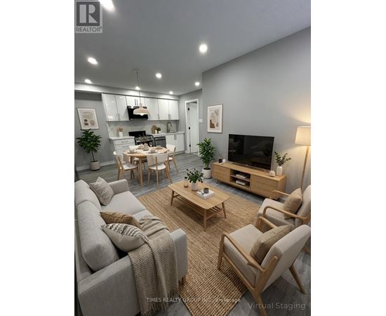 A modern living room with a grey couch, wooden chairs, and a television.
