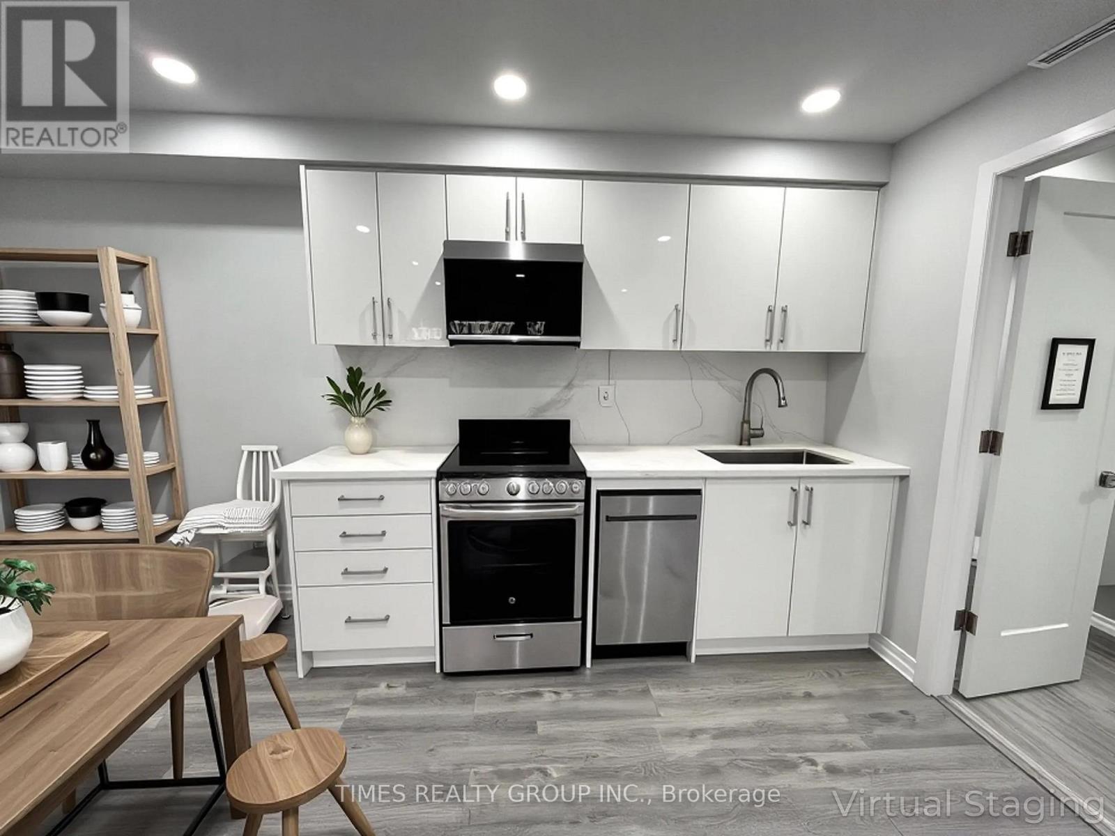 A modern kitchen with white cabinets and stainless steel appliances.