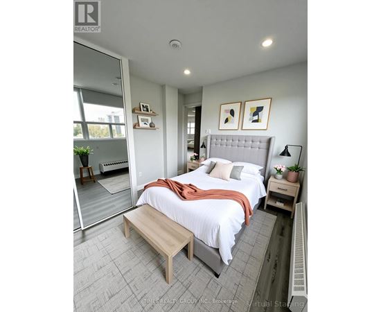 A bedroom with a bed, nightstand, and a window.