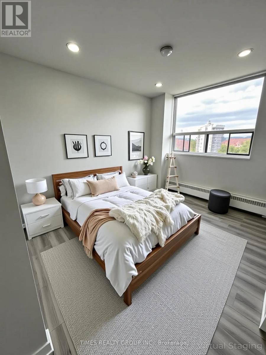 A bedroom with a large bed and a window overlooking a cityscape.