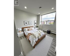 A bedroom with a large bed and a window overlooking a cityscape.